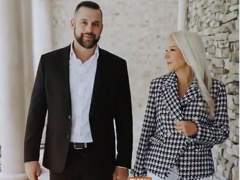 Kelly Schuit & a team member, both Maryland Relators, are walking next to a building.